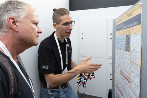 Marius Trollmann specifying his poster “One Ring to Rule Them All: Lugdunin’s Disruptive Effects.” Additional posters were presented by: Prof. Dr. Petra Imhof with "NA-Repair Mechanisms: Molecular Simulations and Computational Alchemy", Dr. Anna Kahler with “Improving MD performance on HPC clusters through in-depth hardware knowledge and advanced program usage”, Dr. Alireza Ghasemi with “Incorporating electrostatic interactions in machine learning interatomic potentials,” PD Dr. Anselm Horn with "Novel Antiviral Strategies: Structure-Based Design and Optimization of PG16-Antibody Derived CDRH3 Peptides against HIV1," and scholarship student Olena Denysenko with "Identification and structural characterization of peptidic ligands for novel antiviral strategies against SARS-CoV-2." (Image: Jürgen Aloisius Morgenroth)