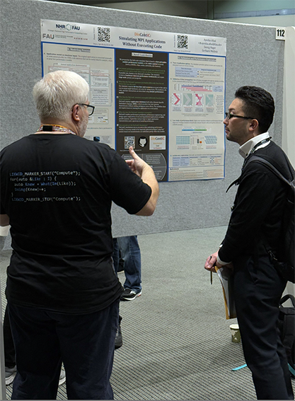 Dr. Georg Hager discussing a scientific poster with a visitor.
