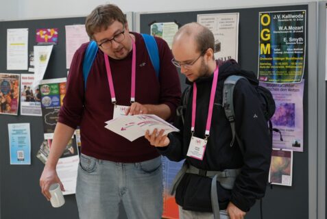 Two NHR@FAU colleagues examine the program flyer, Image: J. Carl (NHR@FAU)