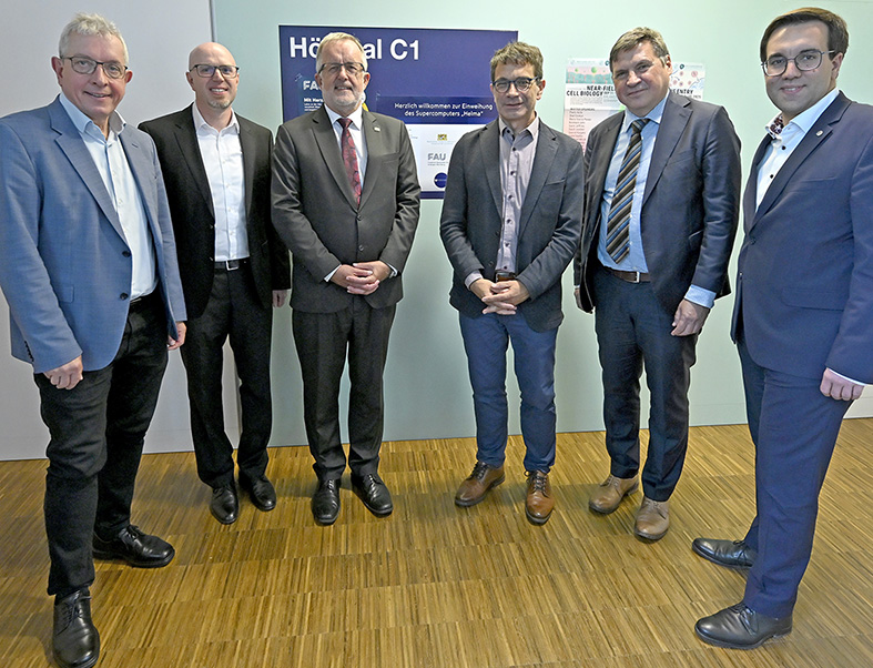 The image shows six men standing together indoors on a wooden floor. They are all dressed formally, wearing suits or blazers, collared shirts, and dress shoes. The group appears to be posing for a formal photo, perhaps to commemorate a meeting, presentation, or announcement. From left to right: Prof. Wolfram Burgard (Nuremberg University of Technology, UTN), Prof. Eduard Kromer (Landshut University of Applied Sciences), Prof. Jürgen Lehmann (President, Hof University of Applied Sciences), Prof. Gerhard Wellein (Director, Center for National High Performance Computing Erlangen, NHR@FAU), Mdgt. Michael Greiner (Head of Department Z, Bavarian State Ministry of Science and the Arts), Dr. Konrad Körner, Member of the German Bundestag and 1st Deputy Chairman, Young Group of the CDU/CSU parliamentary group in the Bundestag.